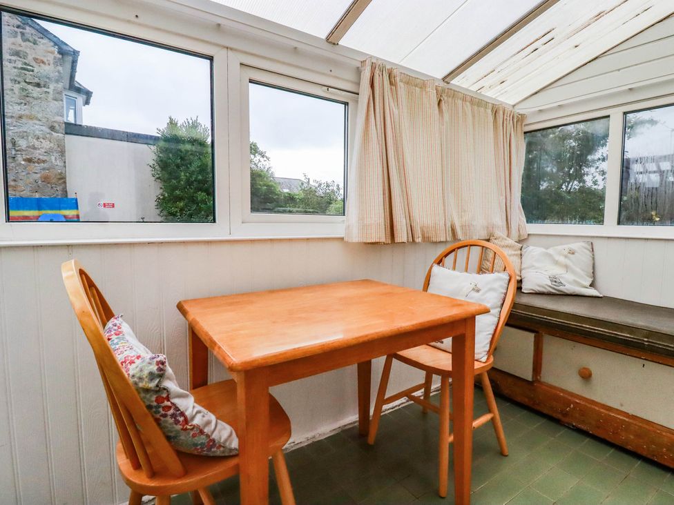 A conservatory with a table and chairs at Harford