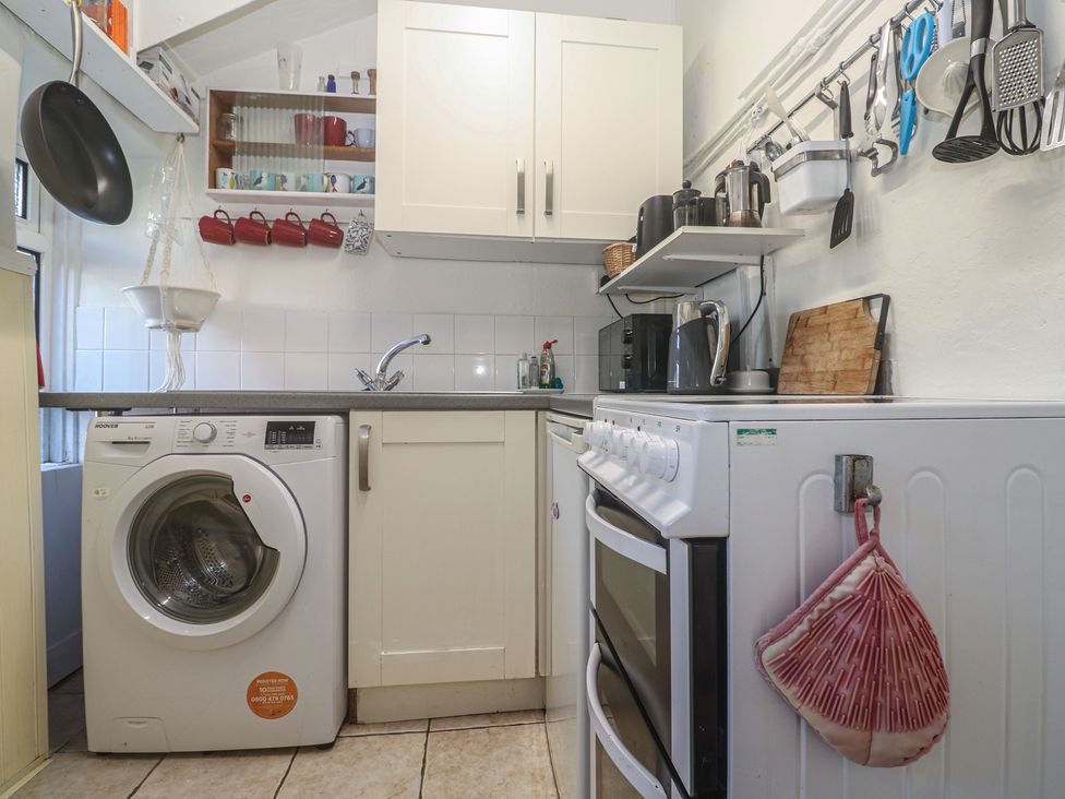 A kitchen with a washing machine and cooking appliances at Harford in Goldsithney
