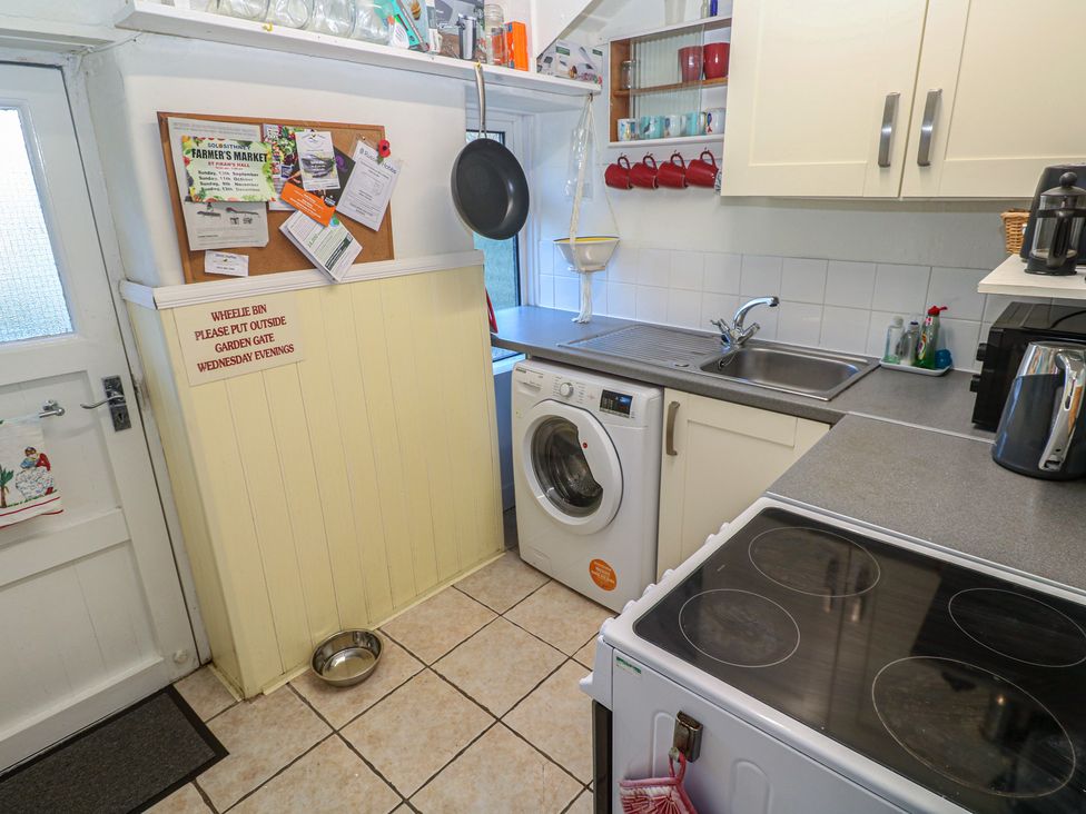 A kitchen with a washing machine and sink at Harford in Goldsithney