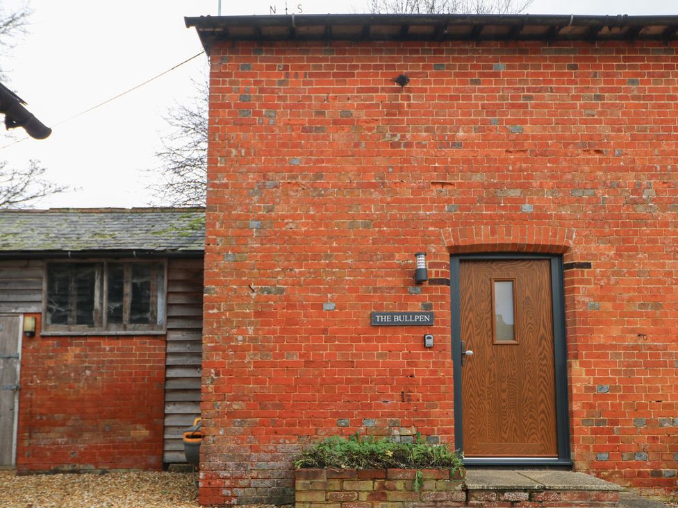 An entrance with a brick wall and door at The Bullpen in West Tytherley