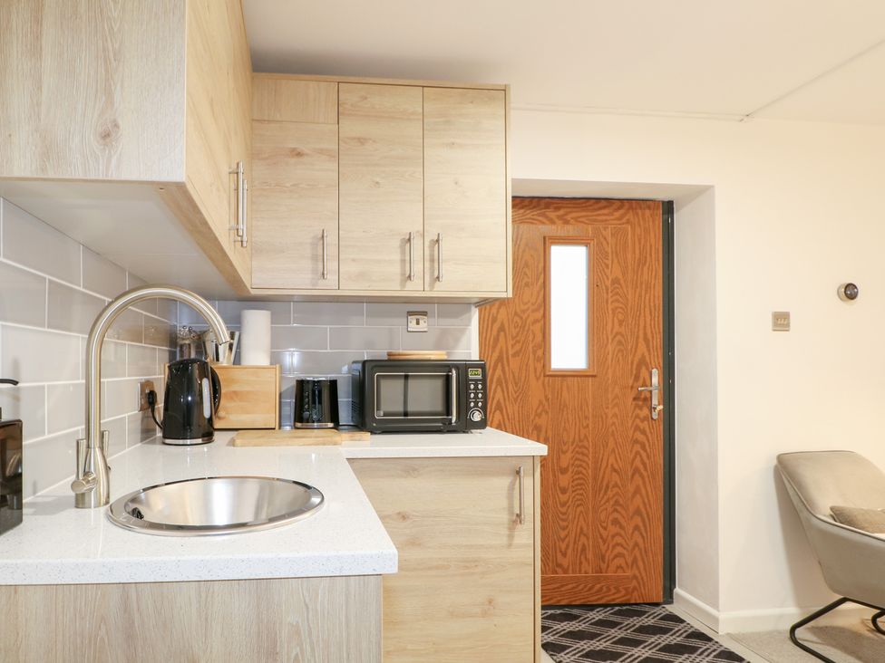 A kitchen with a sink, kettle, and microwave at The Bullpen in West Tytherley