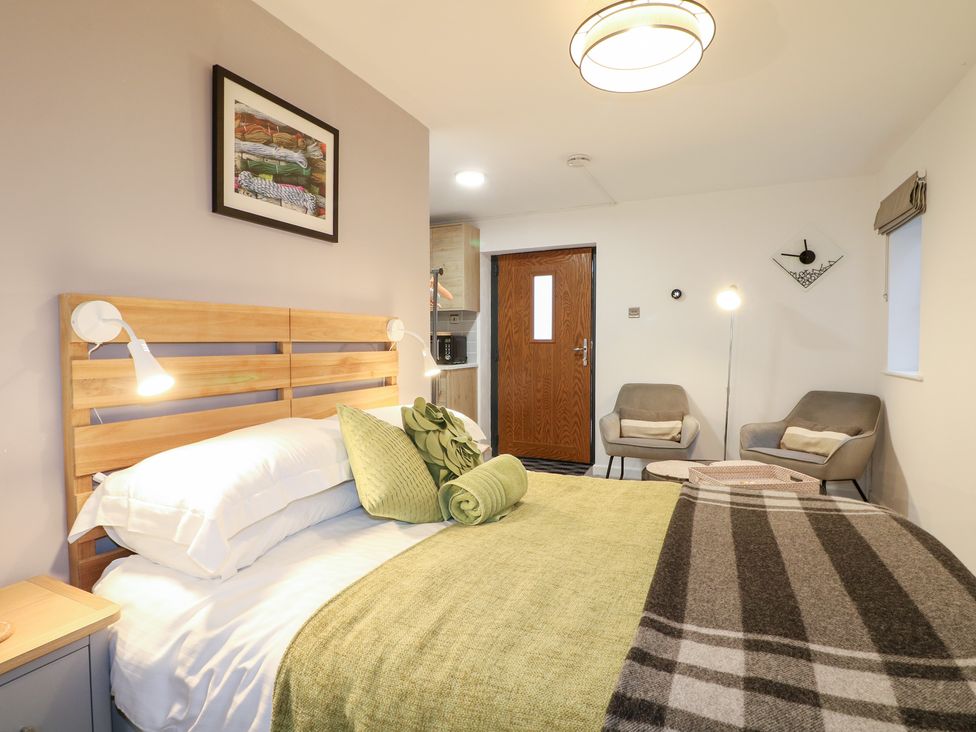 A bedroom with a bed and seating area at The Bullpen in West Tytherley