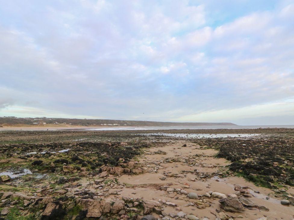 A beach area with rocks and sand at The Boat House - Port Eynon