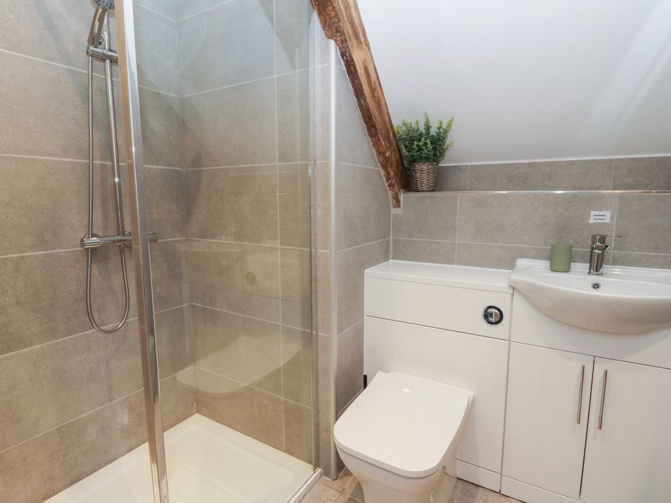 A bathroom with shower, toilet, and sink at The Boat House - Port Eynon