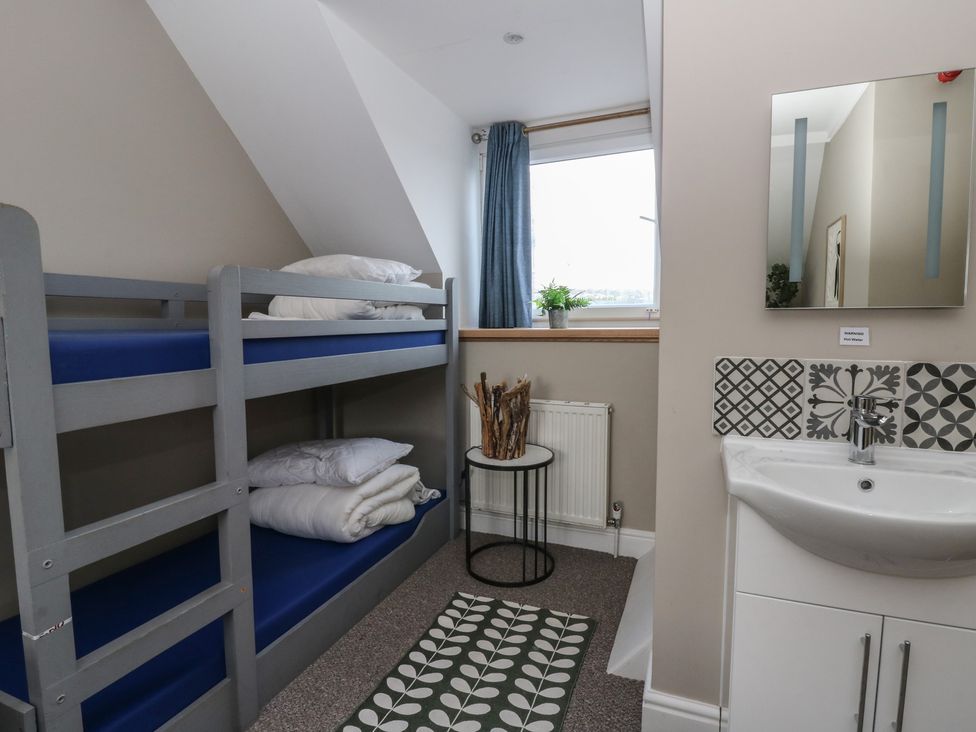 A bedroom with a bunk bed and sink at The Boat House - Port Eynon