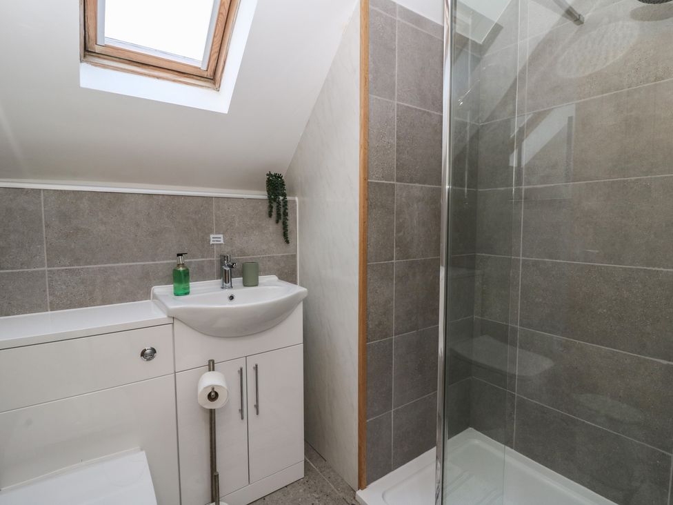 A bathroom with a sink and shower at The Boat House - Port Eynon