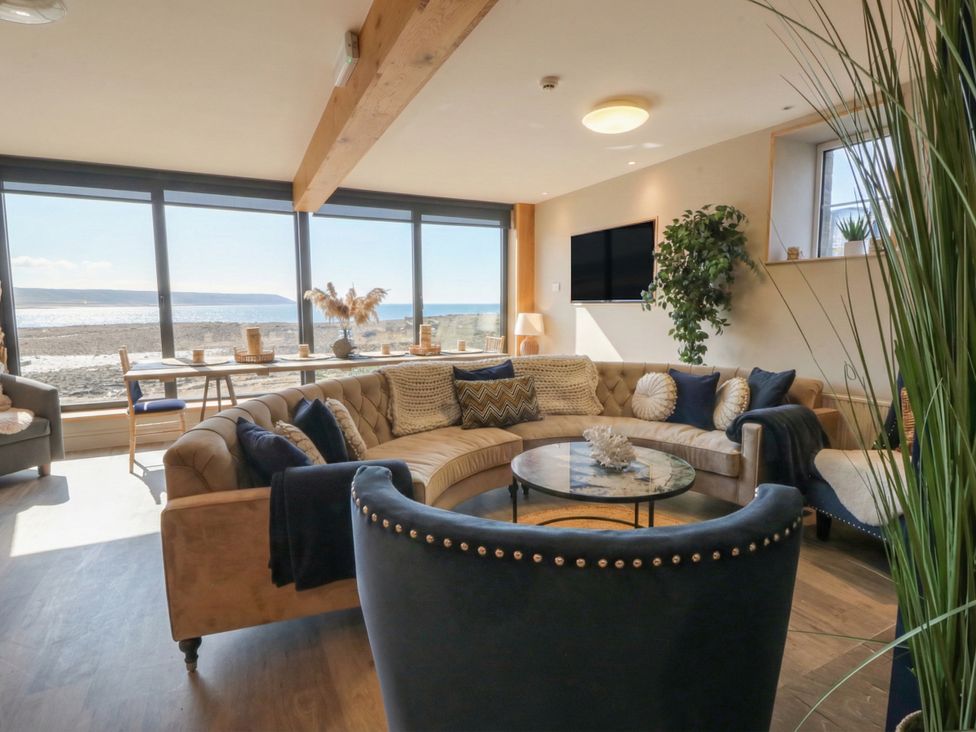 A living room with a sofa and coffee table at The Boat House - Port Eynon