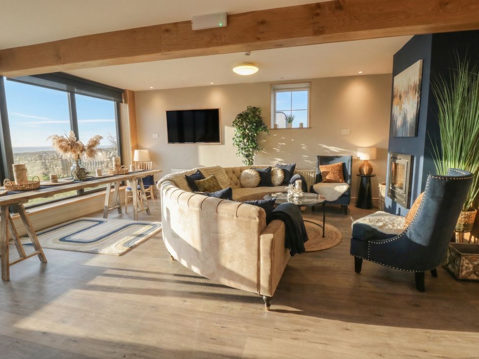 A living room with a sofa and armchairs at The Boat House - Port Eynon