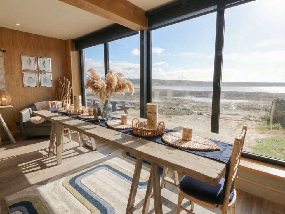 A dining room with a table and chairs at The Boat House - Port Eynon