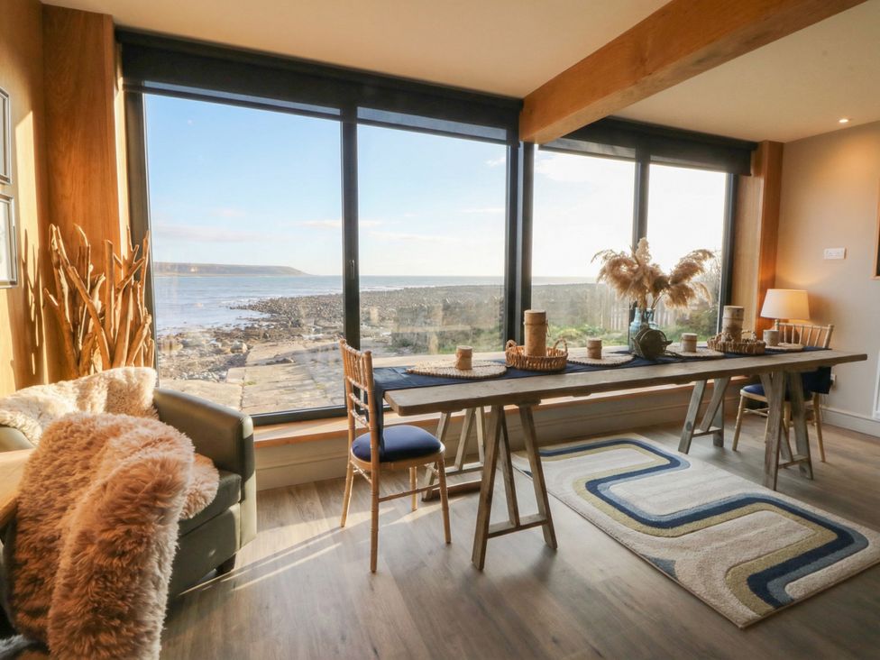 A dining area with a table and chairs at The Boat House - Port Eynon