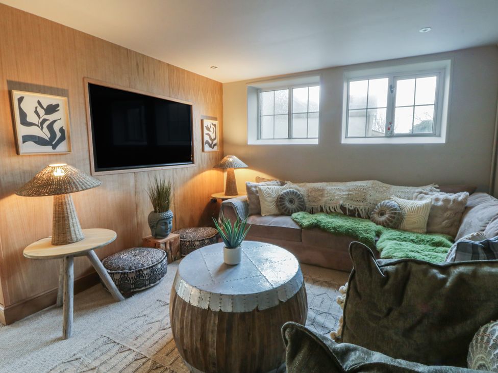 A living room with a sofa and television at The Boat House - Port Eynon