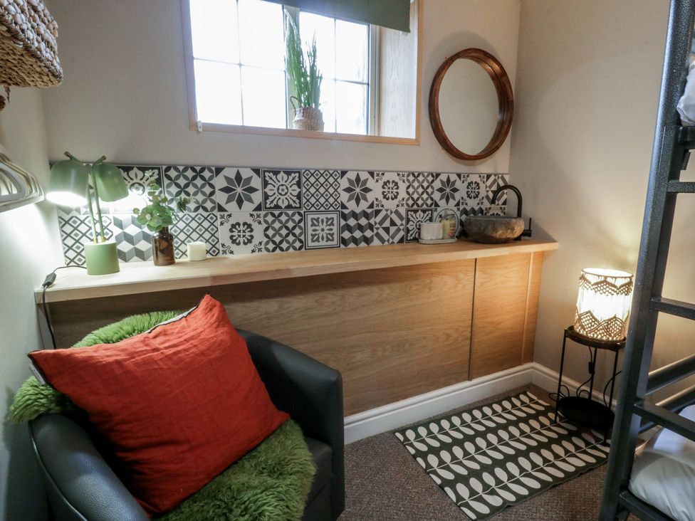 A snug with a chair and a sink at The Boat House - Port Eynon