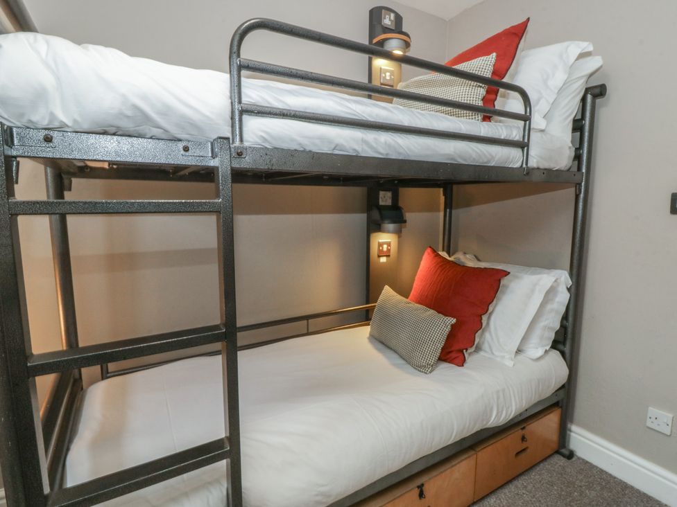 A bunk bed with pillows and bedside lights at The Boat House - Port Eynon