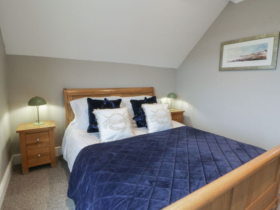 A bedroom with a bed and bedside tables at The Boat House - Port Eynon