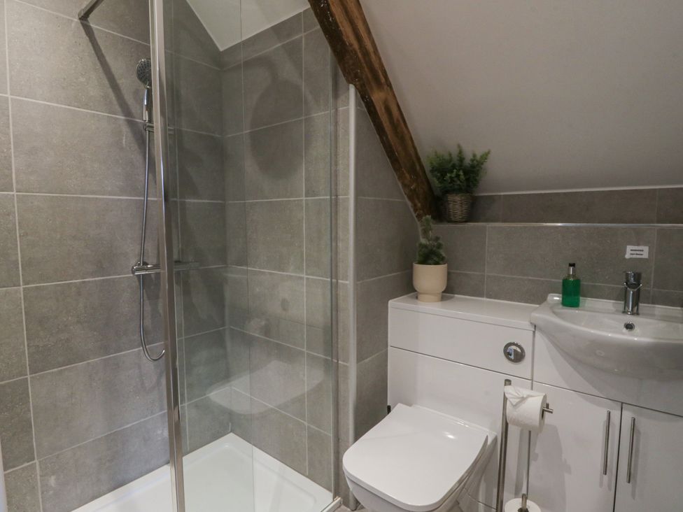 A bathroom featuring a shower, toilet, and sink at The Boat House - Port Eynon