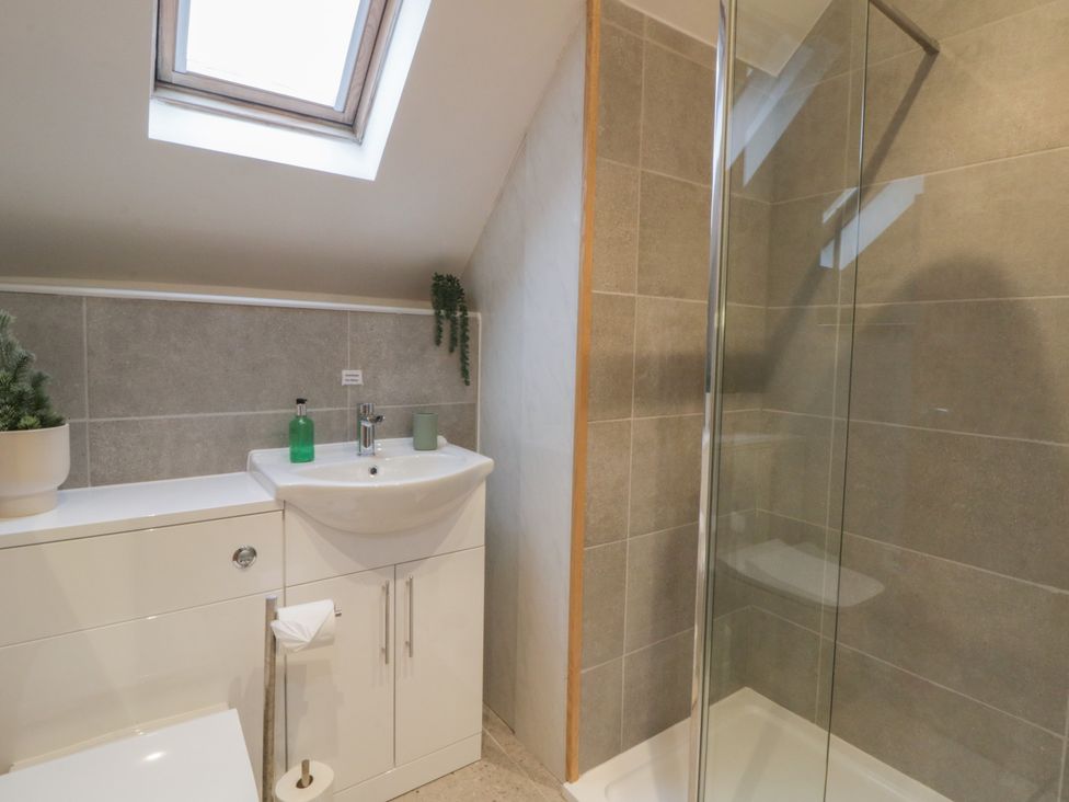 A bathroom with a shower and sink at The Boat House - Port Eynon