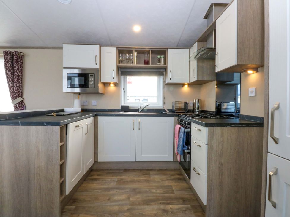 A kitchen with an oven and microwave at Blue Skies in Caernarfon