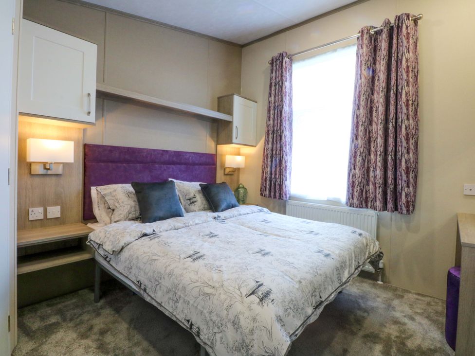 A bedroom with a double bed and two bedside lamps at Blue Skies in Caernarfon