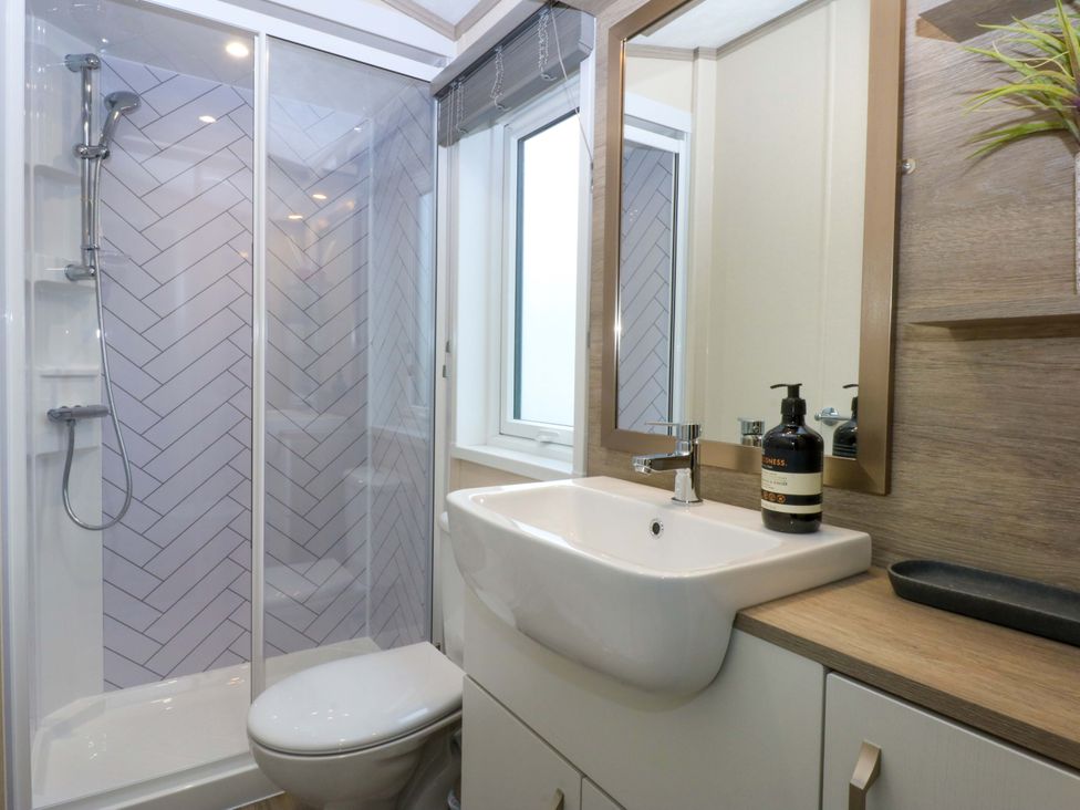 A bathroom with a shower, sink, and toilet at Blue Skies in Caernarfon