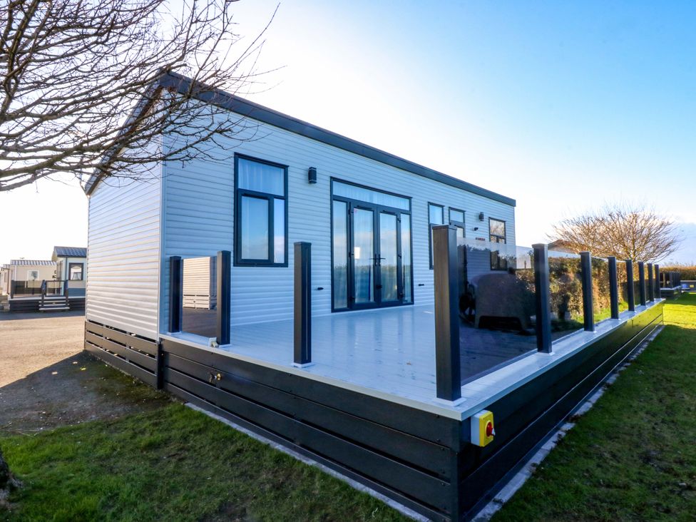 A house with a deck and railings at Blue Skies Near Caernarfon