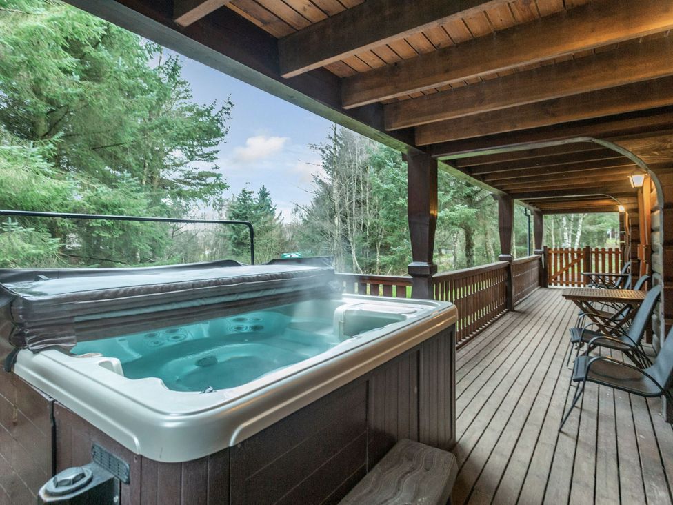 An outdoor area with a hot tub and seating at Kinder Lodge (Pet) Fowlis near Dundee