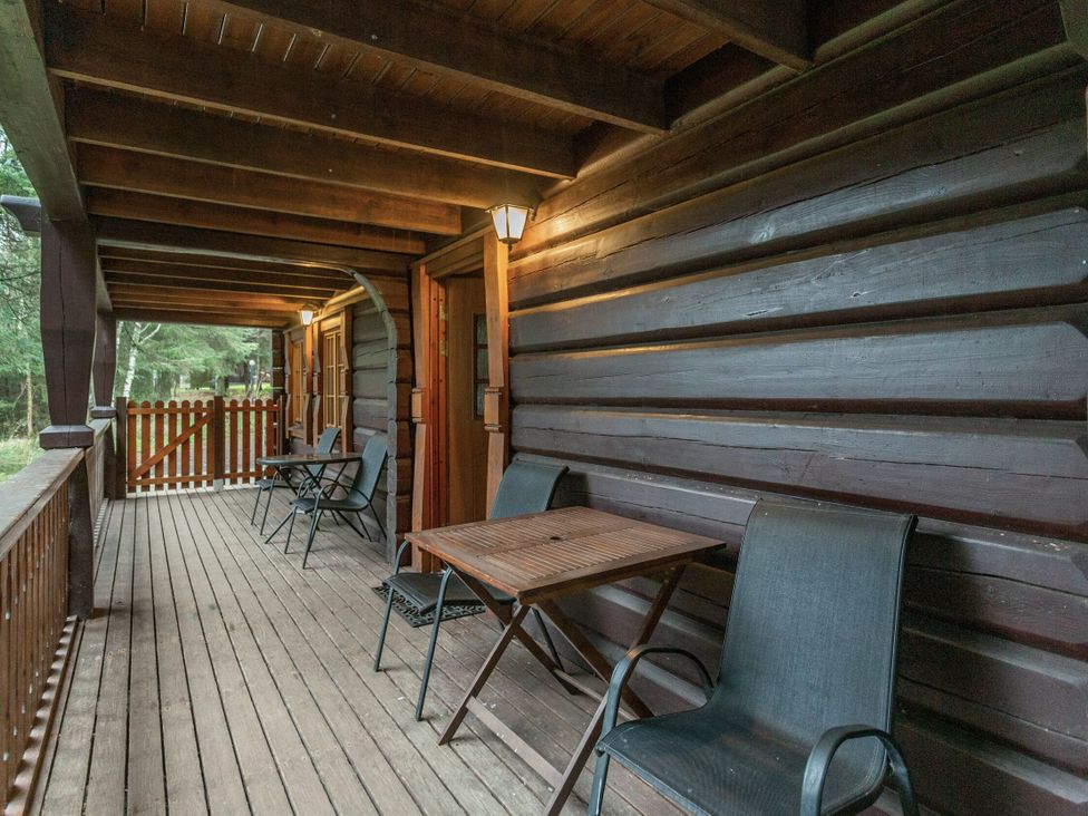 An outdoor deck with chairs and a table at Kinder Lodge (Pet) Fowlis near Dundee