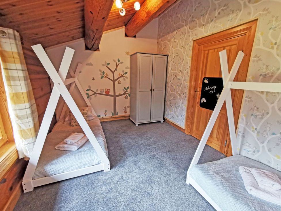 A bedroom with bunk beds and a wardrobe at Kinder Lodge (Pet) Fowlis near Dundee