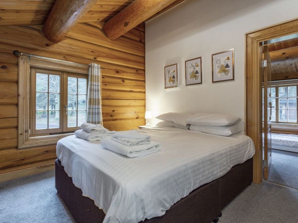 A bedroom with a bed and window at Kinder Lodge (Pet) Fowlis near Dundee
