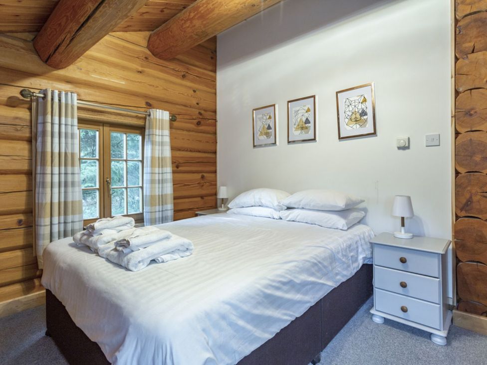 A bedroom with a bed and bedside table at Kinder Lodge (Pet) Fowlis near Dundee