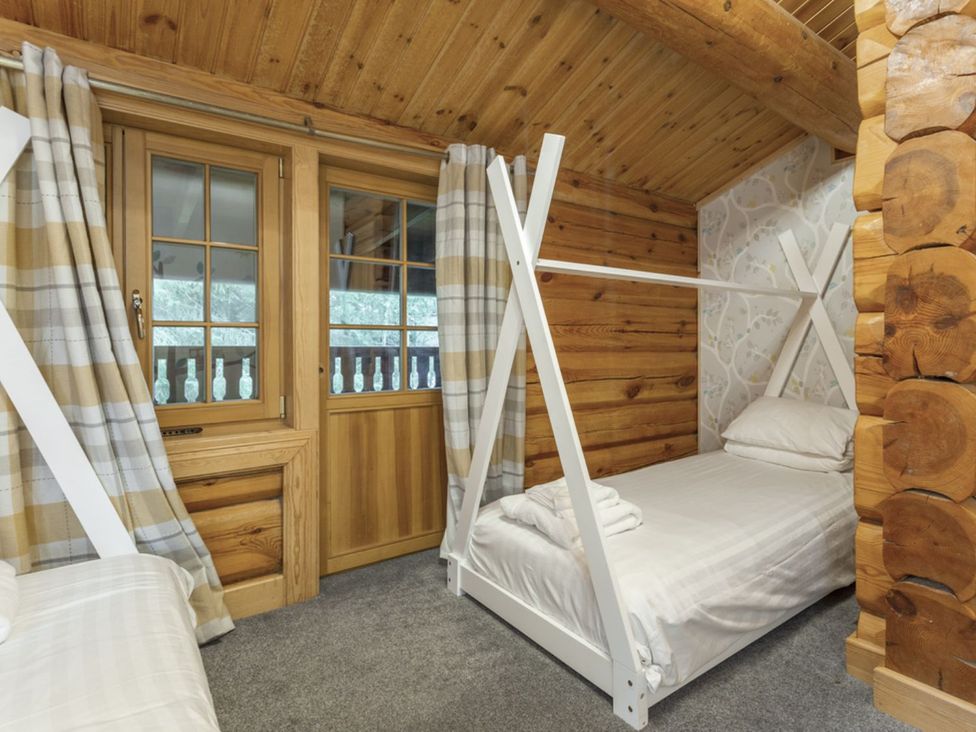 A bedroom with a bunk bed and single bed at Kinder Lodge (Pet) Fowlis near Dundee