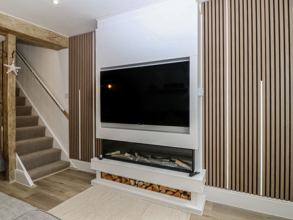 A living room with a television and fireplace at 61A High Street in Criccieth