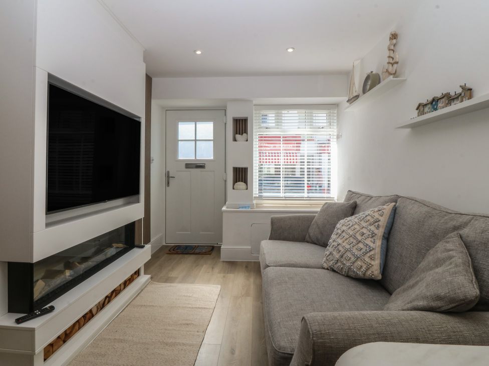 A living room with a television and sofa at 61A High Street in Criccieth