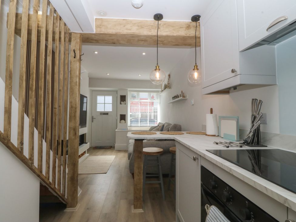 A kitchen with an oven and table at 61A High Street in Criccieth