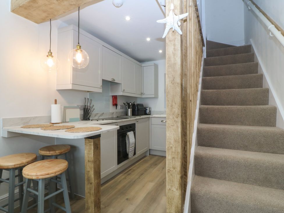 A kitchen with a stove and sink at 61A High Street Criccieth