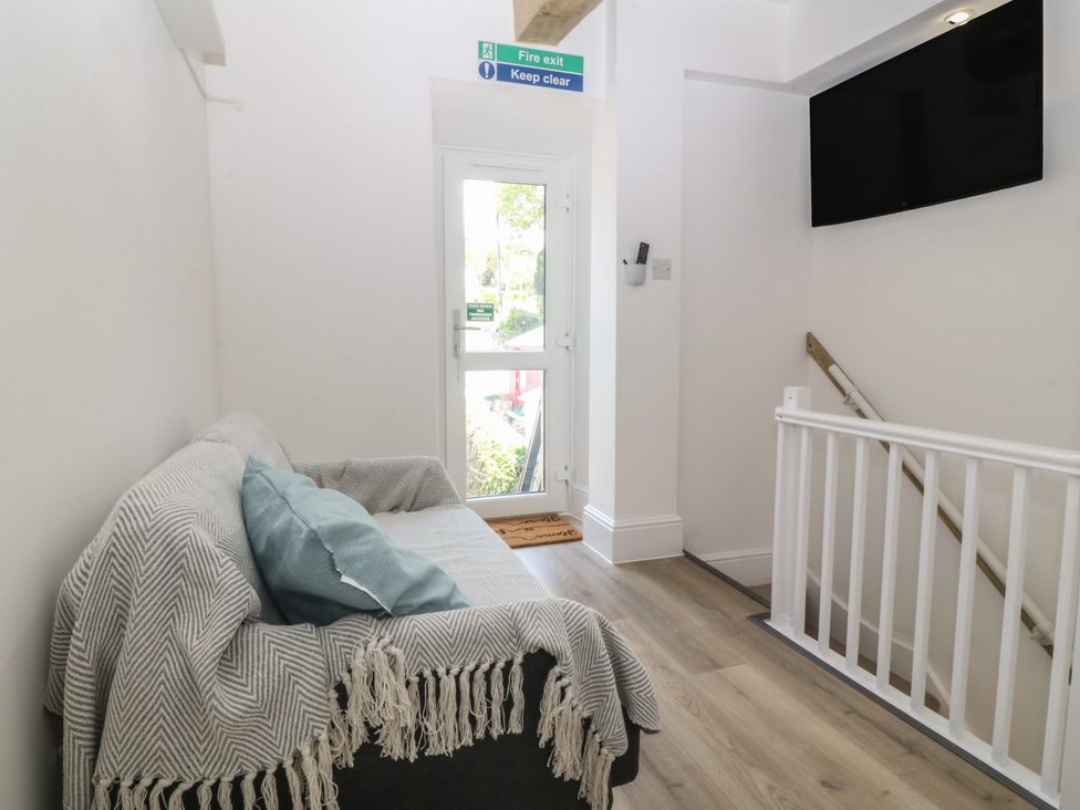 A hallway with a sofa and a door at 61A High Street Criccieth