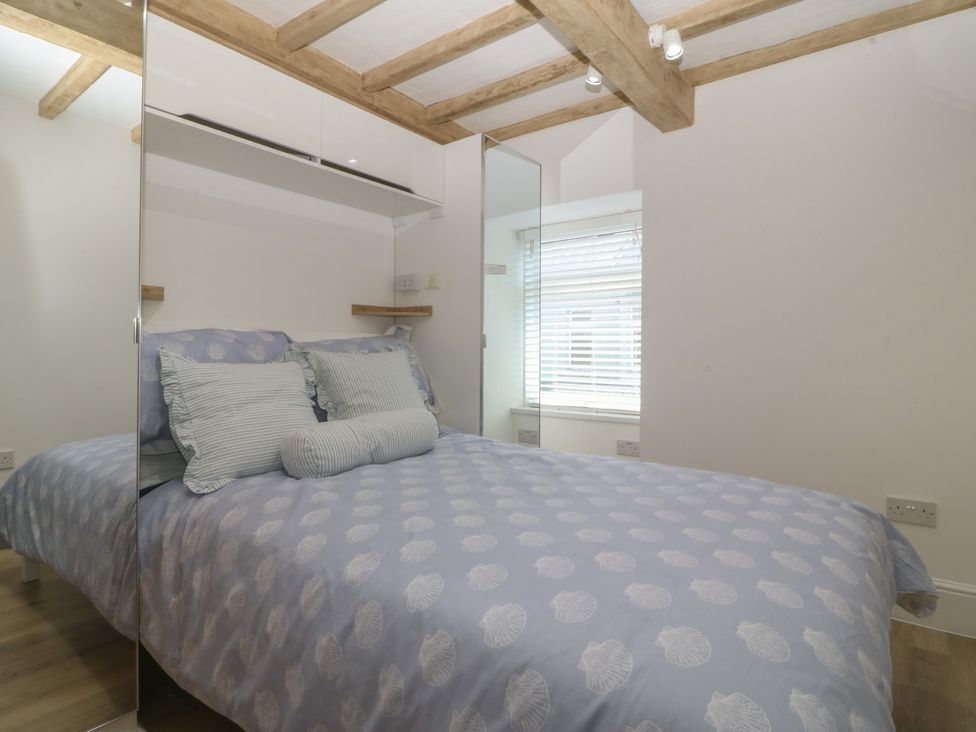 A bedroom with a bed and pillows at 61A High Street in Criccieth