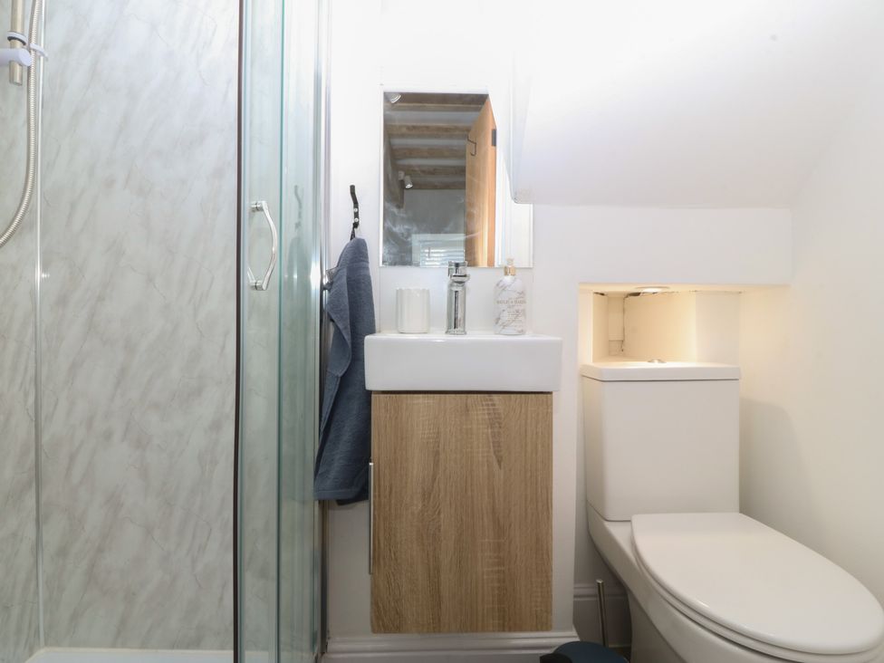 A bathroom with shower, sink, and toilet at 61A High Street in Criccieth