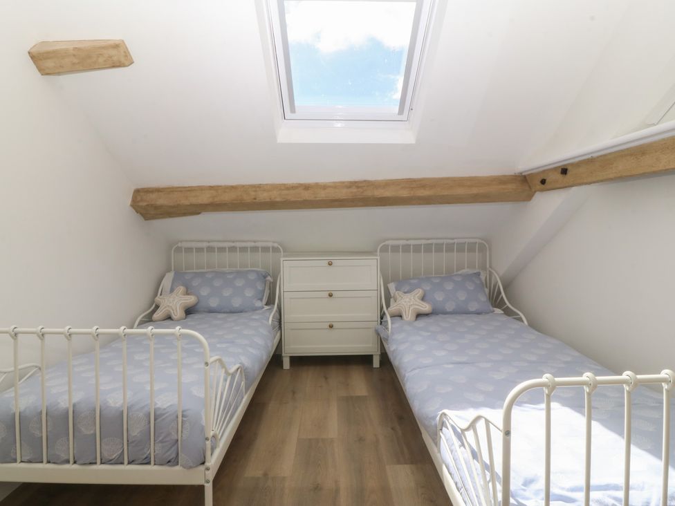 A bedroom with two beds and a dresser at 61A High Street, Criccieth
