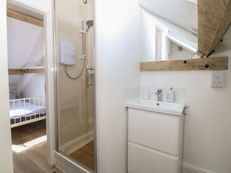 A bathroom with a shower and sink at 61A High Street in Criccieth