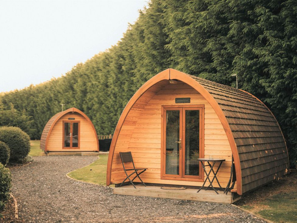 Two wooden garden pods with a pathway at Garden Pod in Waltham