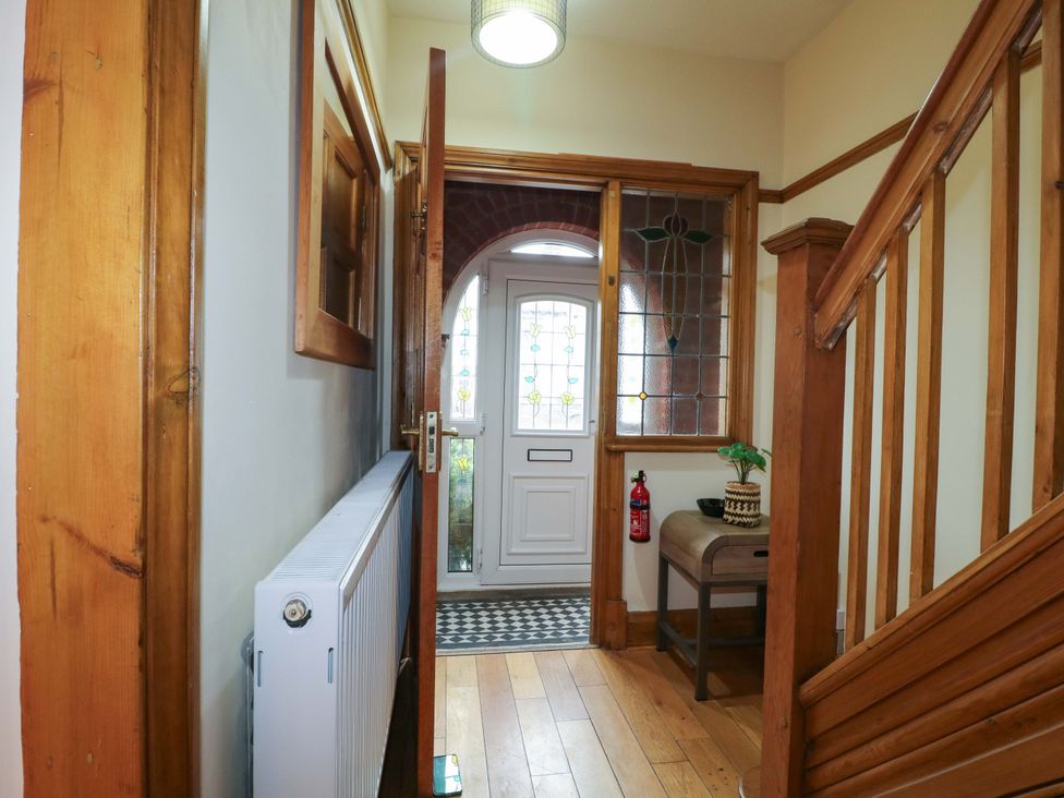 A hallway with a front door and staircase at 5 Wallace Road Loughborough