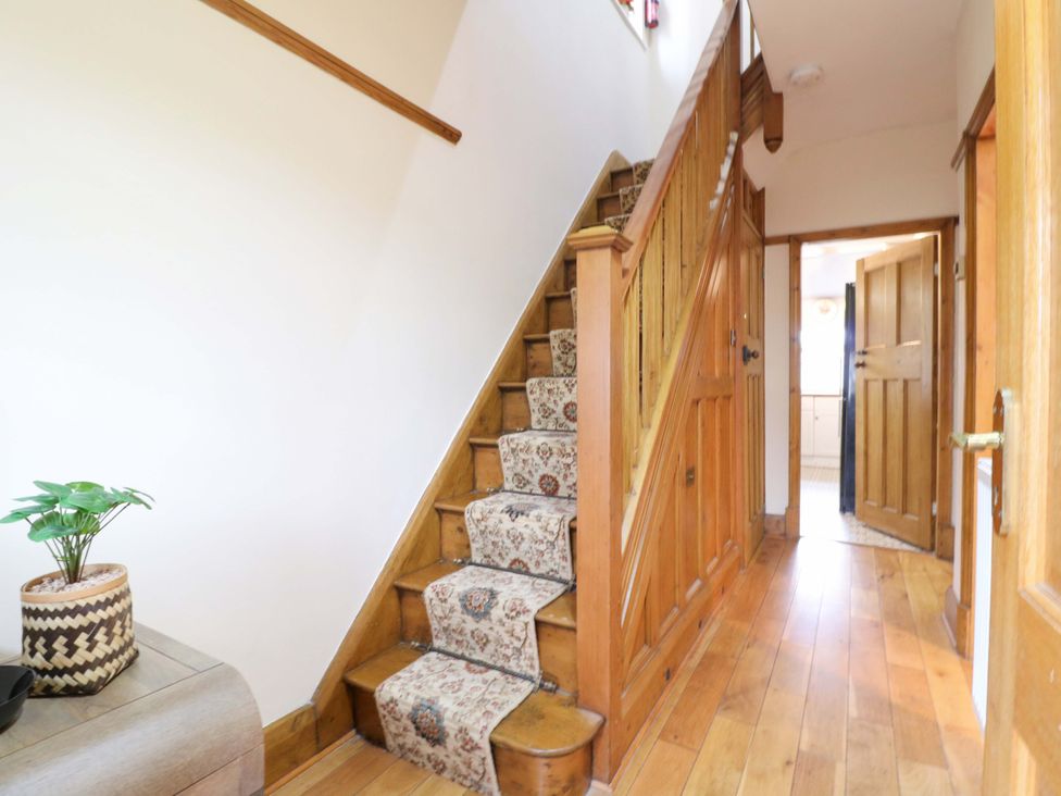 A hallway with a staircase and a potted plant at 5 Wallace Road in Loughborough