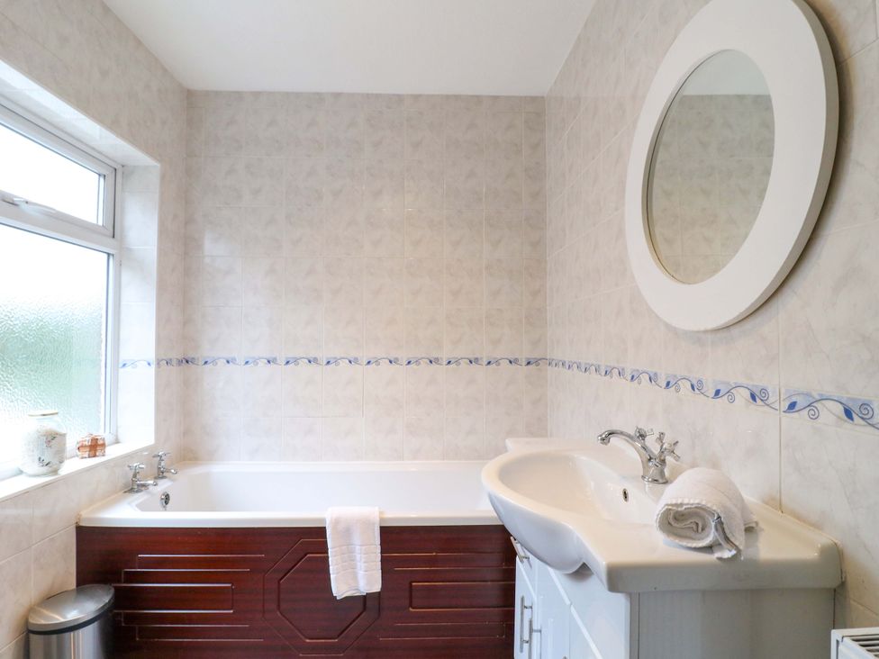 A bathroom with a bath tub and sink at 5 Wallace Road Loughborough