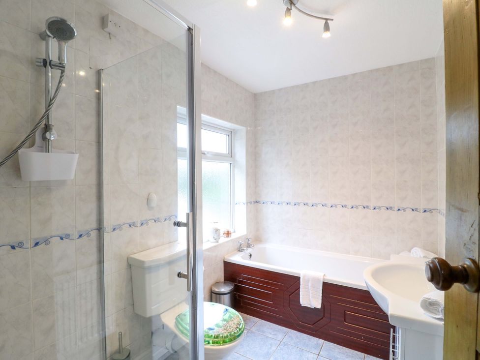 A bathroom with shower, toilet, bathtub, and sink at 5 Wallace Road, Loughborough