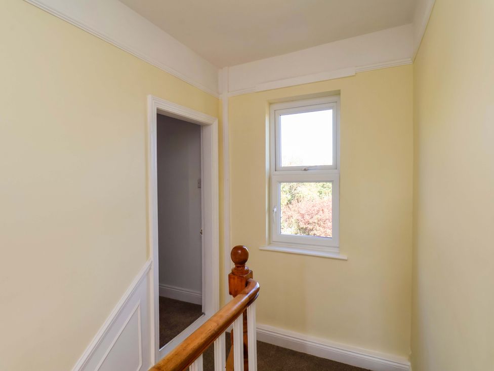 A hallway with a staircase and a window at 22 The Lane Saltburn-by-the-Sea