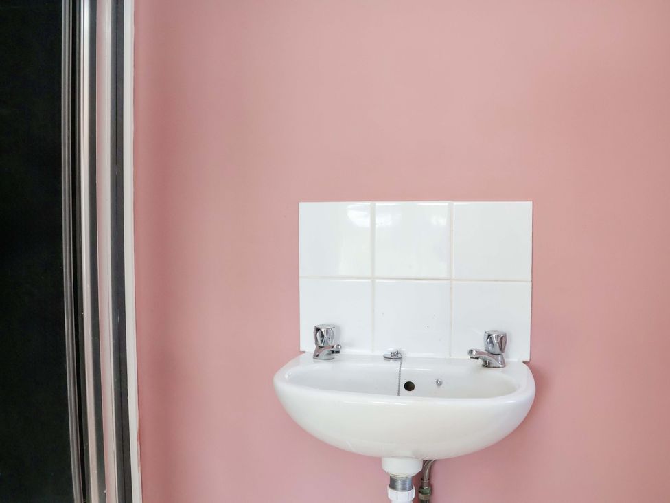 A sink with two faucets and tiles on the wall at 22 The Lane Saltburn-by-the-Sea