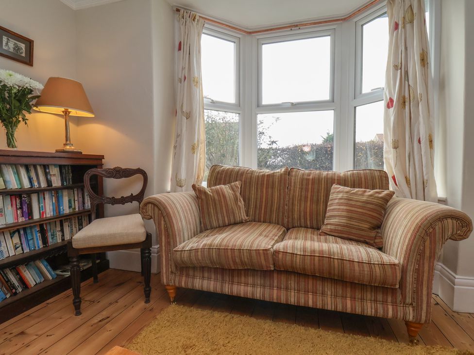 A living room with a sofa and bookshelf at The Manse in Whitby