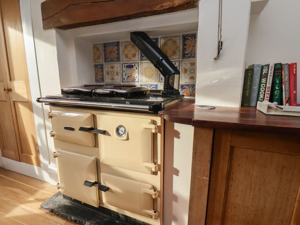 A kitchen with a cream stove and books on a wooden countertop at The Manse in Whitby