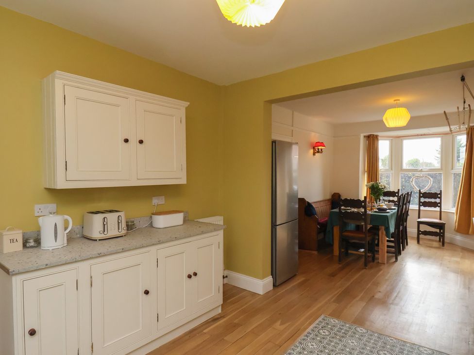 A kitchen with cabinets and a dining area at The Manse in Whitby