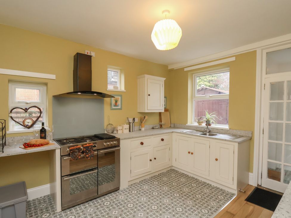 A kitchen with stove, sink, cabinets, and countertop at The Manse in Whitby